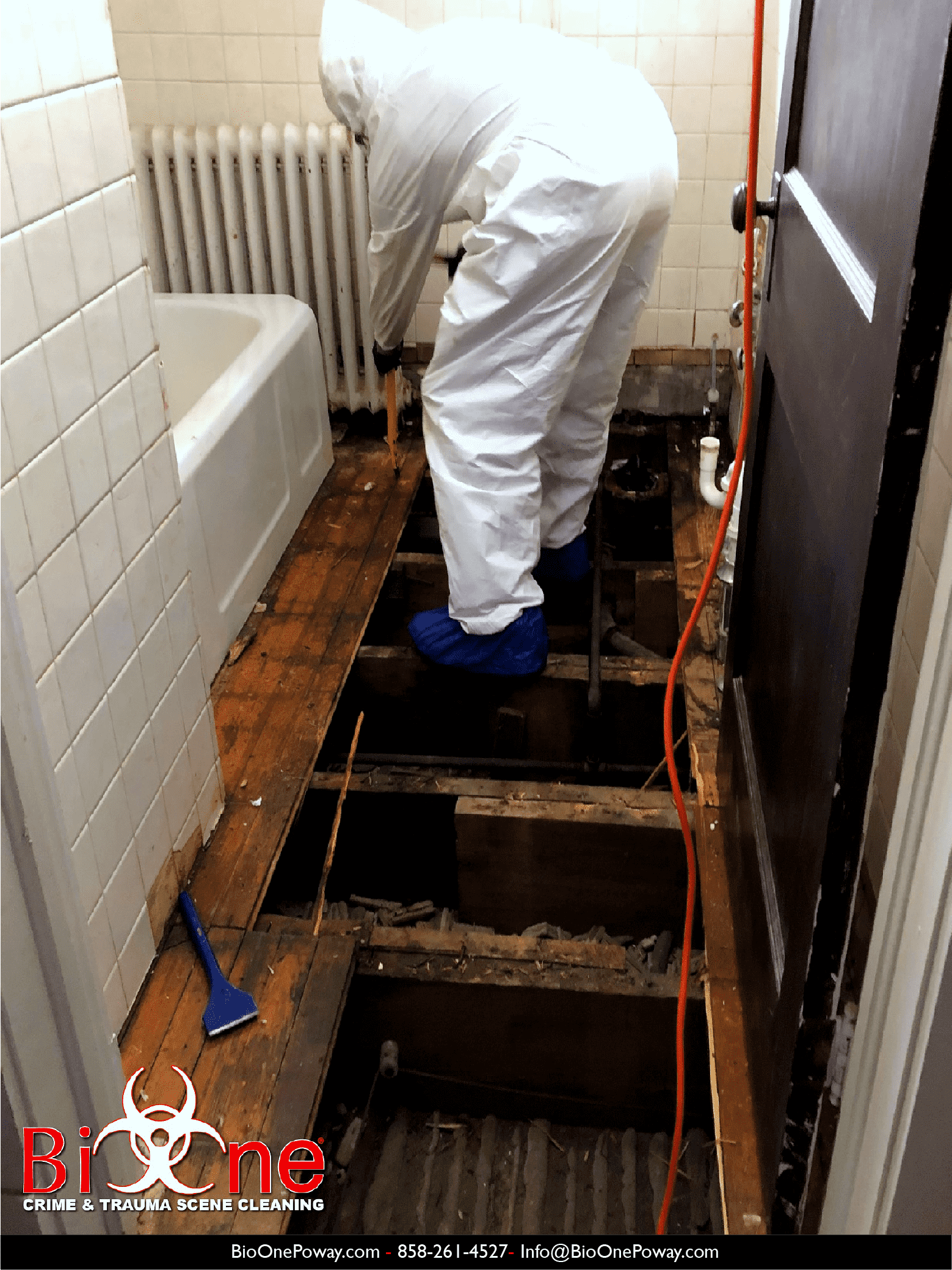 Image shows Bio-One technician removing  hardwood flooring damaged by mold in a bathroom.