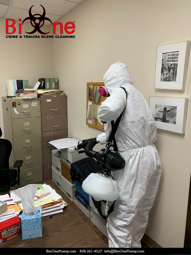 Image shows Bio-One remediation technician using fogging technique to disinfect a commercial property.