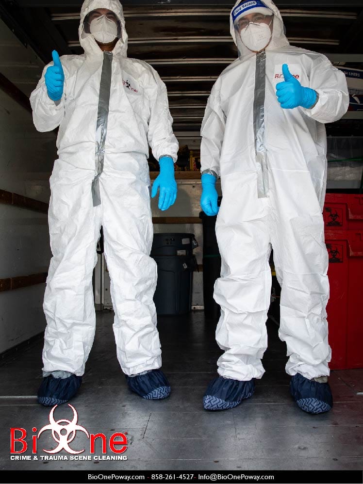 Image shows Bio-One restoration technicians wearing full PPE.